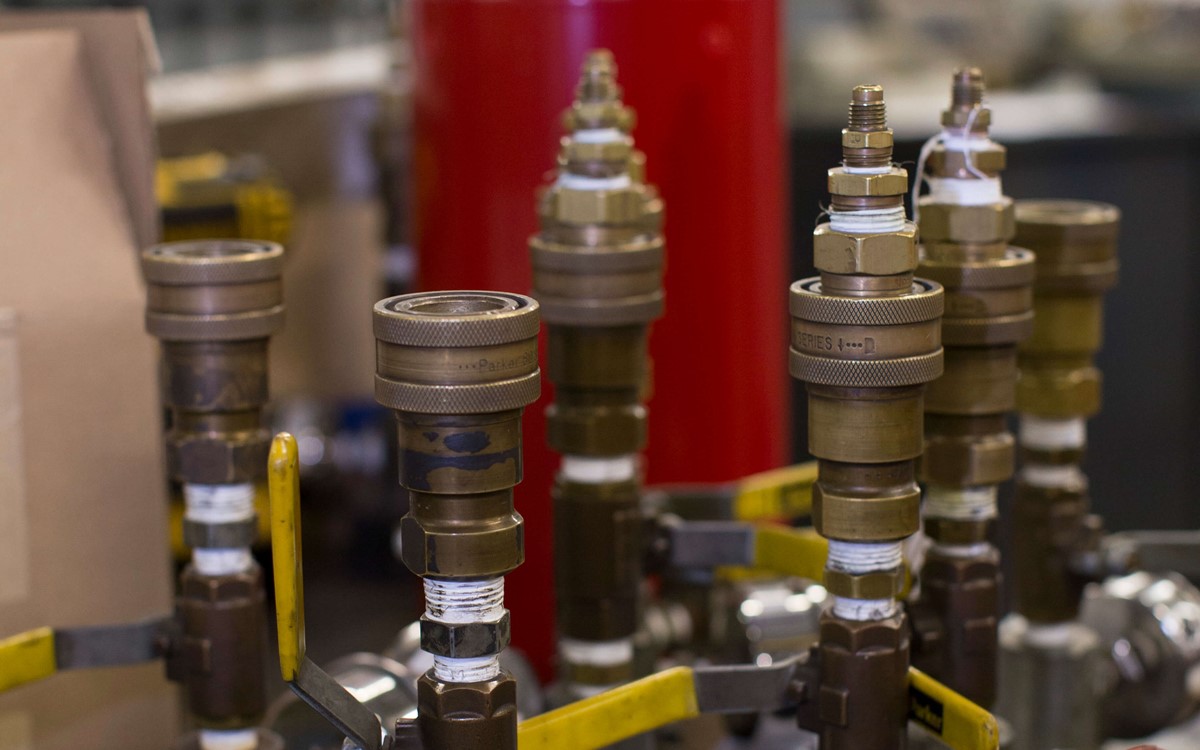 Cylinder valves sat on top of a table next to each other, they aren't connected to a cylinder