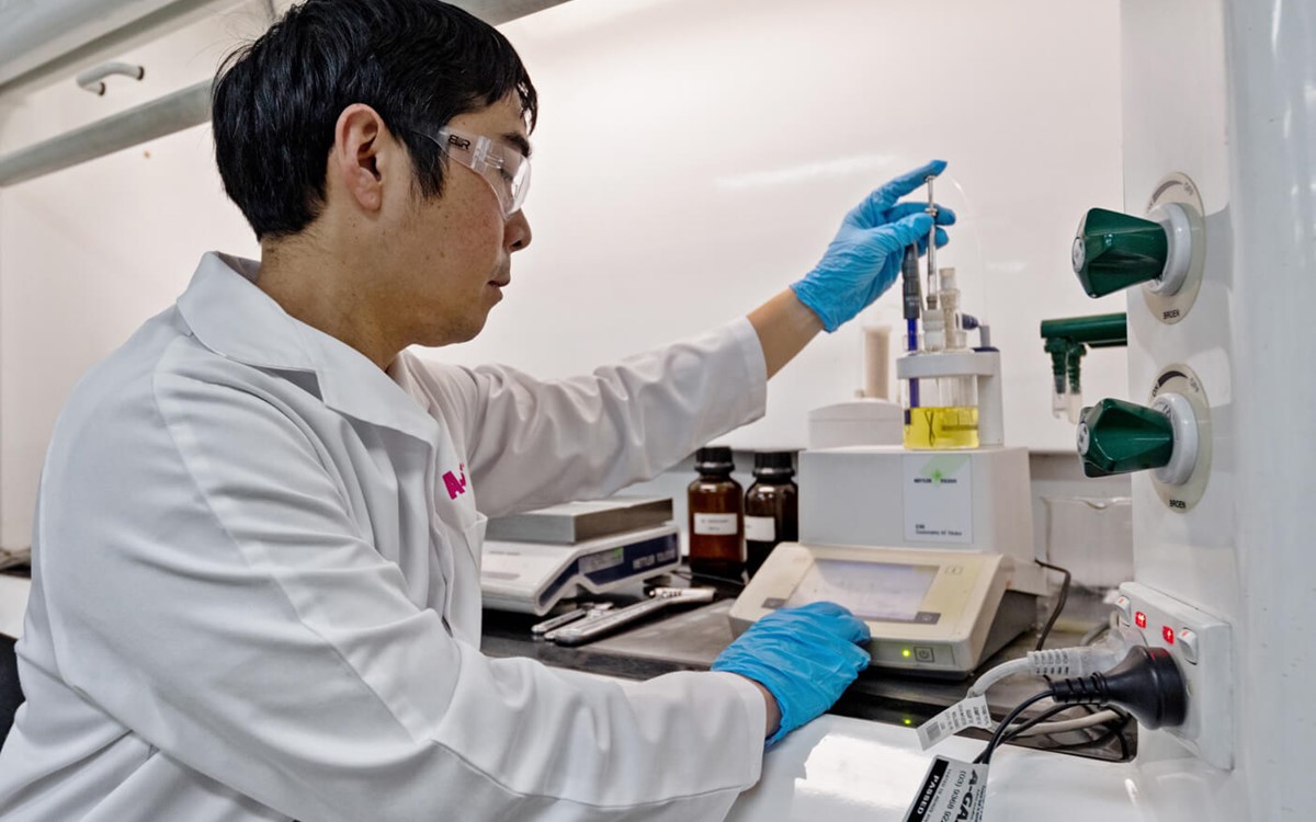 Close-up of a man in a white coat using laboratory equipment 