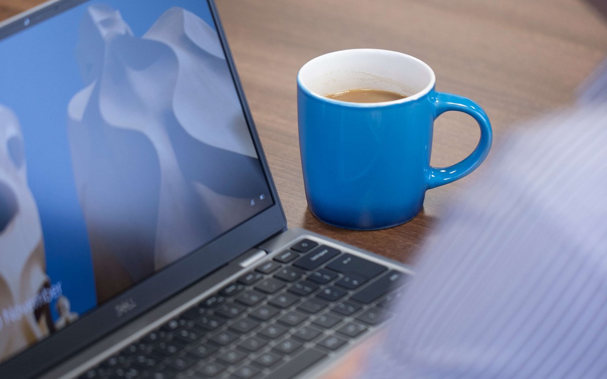 working on a laptop with a cup of coffee