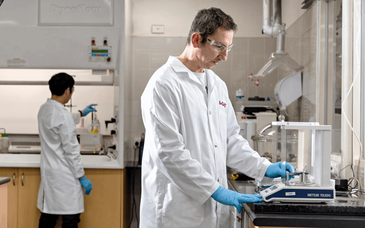 Two men in white coats working with equipment in a laboratory 