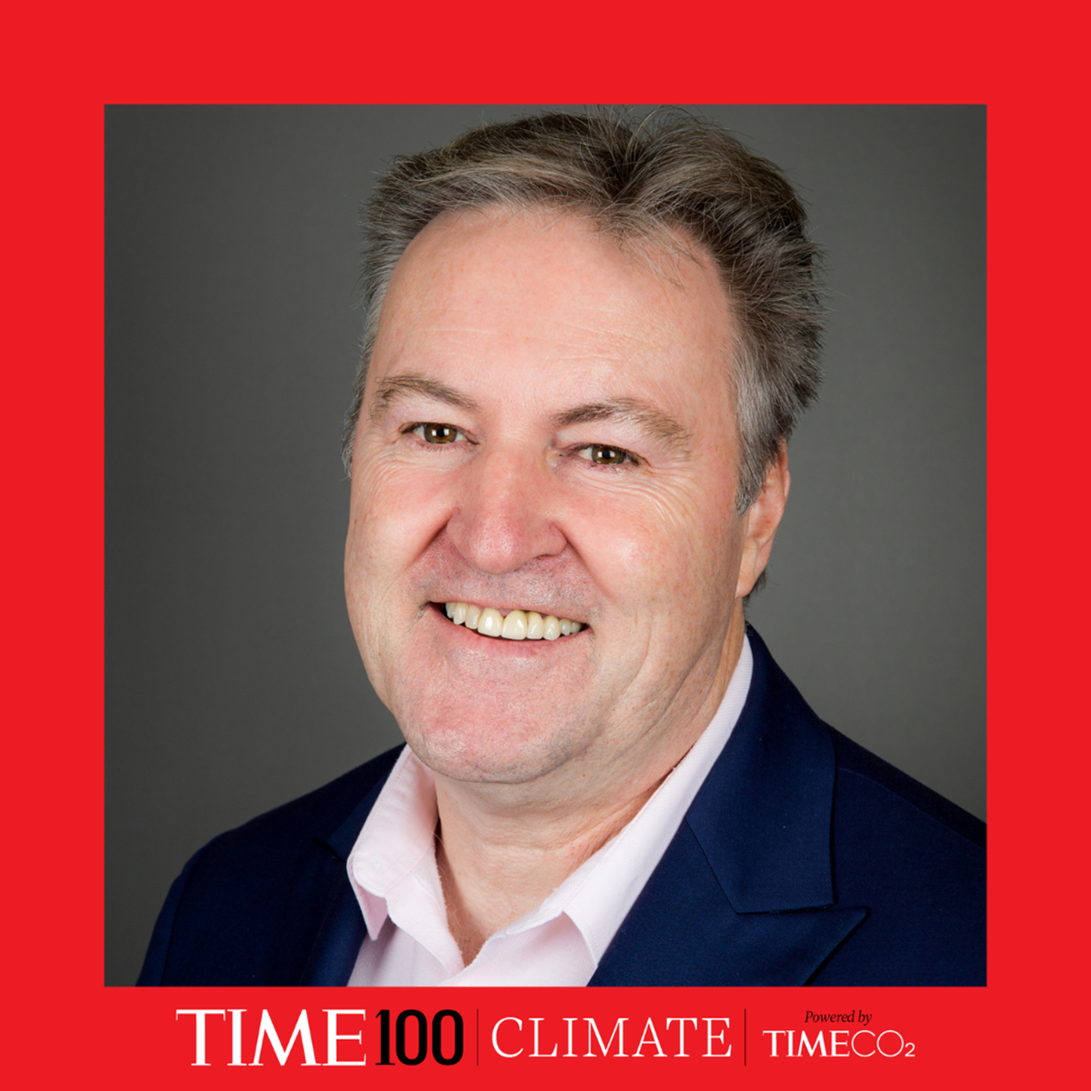 A headshot of a man smiling surrounded by a red border with the TIME 100 logo at the bottom 