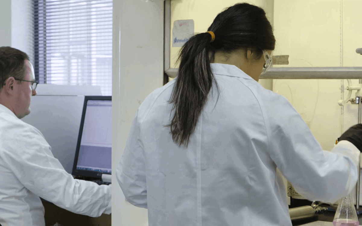 Two lab technicians working, the image is taken from behind